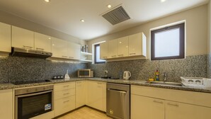 Eine moderne Küche mit Granit-Arbeitsplatten, Edelstahlgeräten und hellen Schränken.