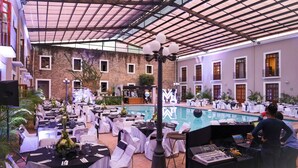 An indoor venue with tables set for a formal event, a pool area, and a DJ booth. - Hotel San Francisco Tlaxcala (Tlaxcala)