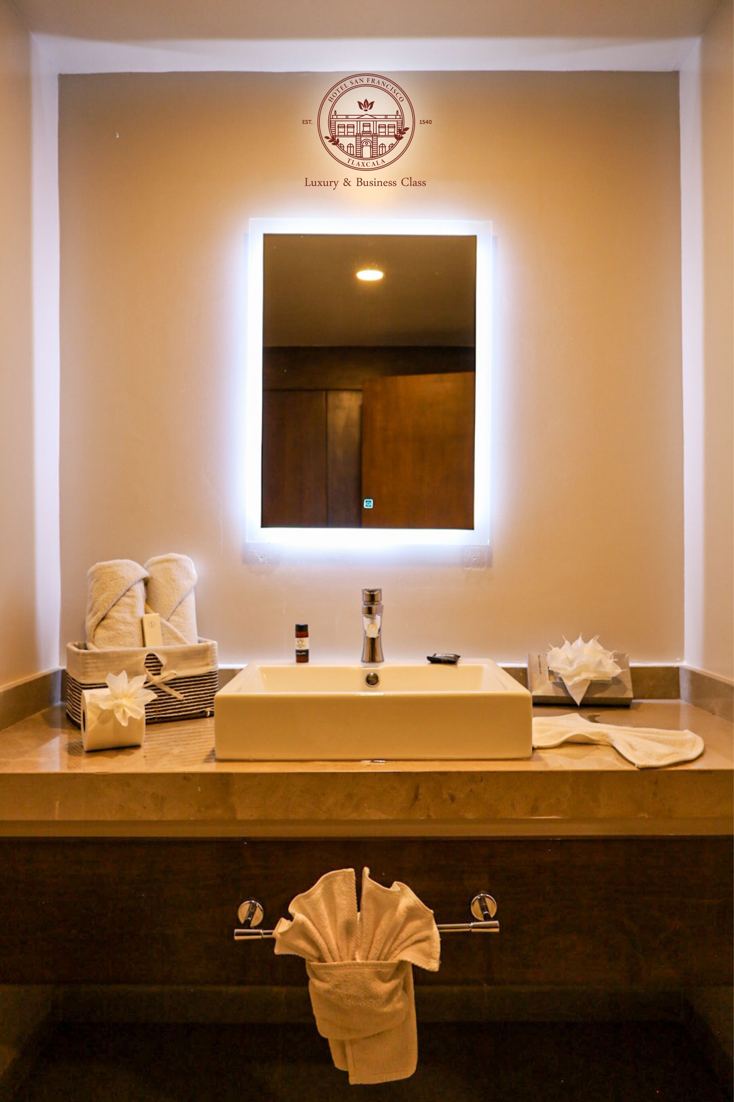 Un baño con un espejo grande, un lavabo y un perchero para toallas.