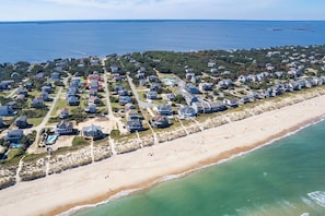 An aerial view of a coastal residential area with houses, a beach, and a large body of water. - Gorgeous! Private Pool, Hot Tub, Game room, Family Friendly, D0115 (Duck)