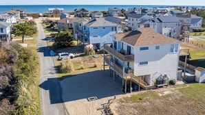 A coastal residential area with houses, a road, and a beach in the background. - Gorgeous! Private Pool, Hot Tub, Game room, Family Friendly, D0115 (Duck)