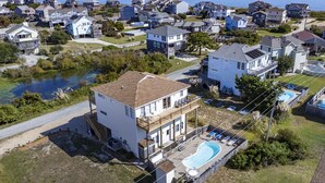 A residential area with houses, a swimming pool, and a body of water. - Gorgeous! Private Pool, Hot Tub, Game room, Family Friendly, D0115 (Duck)