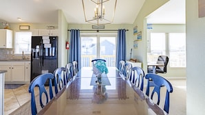 A dining area with a long table, blue chairs, and a chandelier. - Gorgeous! Private Pool, Hot Tub, Game room, Family Friendly, D0115 (Duck)