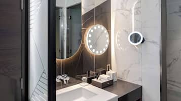 A modern bathroom with a large mirror, two round mirrors, and a white sink.