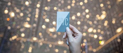 A hand holding a card with "HYC" visible.