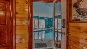 Un interno in legno con una porta in vetro che dà su un'area piscina.