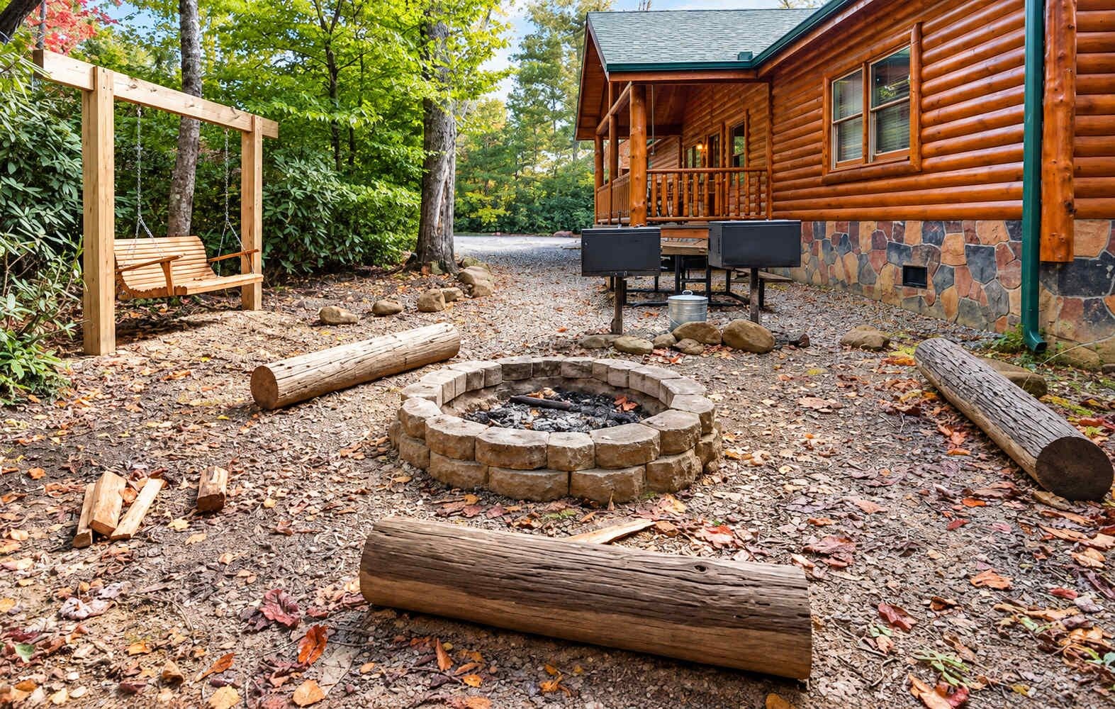 Una cabaña de troncos con chimenea de piedra, un columpio y un área de estar al aire libre techada.