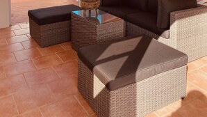 A sunburst wall mural, a wicker sofa, and a view of the ocean. - Walk-up penthouse w/breathtaking views, WiFi, A/C, free laundry, sleeps 6 (Cabo Rojo)