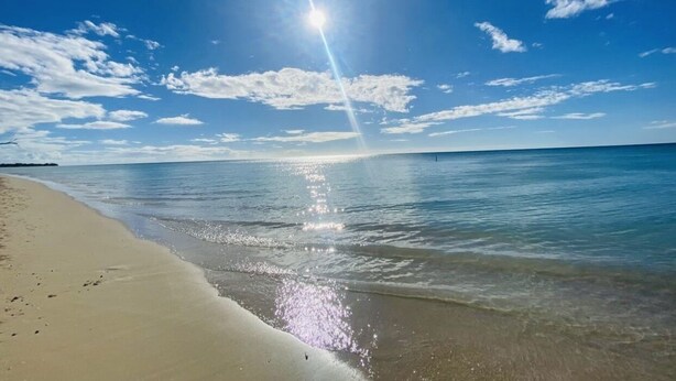 A beach with clear skies and sunlight reflecting on the water. - Walk-up penthouse w/breathtaking views, WiFi, A/C, free laundry, sleeps 6 (Cabo Rojo)