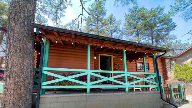 A rustic log cabin with a porch, a door, and a small window. - Rustic Cabin Bordering the Pines, Less than 1mi to DT Square (Prescott)