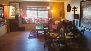 A cozy living room with a sofa, chairs, a coffee table, and a window with blinds. - Rustic Cabin Bordering the Pines, Less than 1mi to DT Square (Prescott)