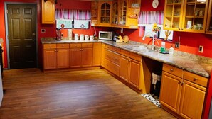 A kitchen with wooden cabinets, a microwave, and a sink. - Rustic Cabin Bordering the Pines, Less than 1mi to DT Square (Prescott)