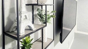 A wall-mounted black metal shelf unit with decorative items and plants. - Walk to dining/bars/parks! Ideal for Red Rocks! (Golden)
