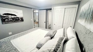 A bedroom with a bed, pillows, a wall-mounted picture, and a door. - Walk to dining/bars/parks! Ideal for Red Rocks! (Golden)