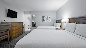 A hotel room with two beds, a dresser, a television, and a painting on the wall. - Welcome Inn (Eagle Pass)