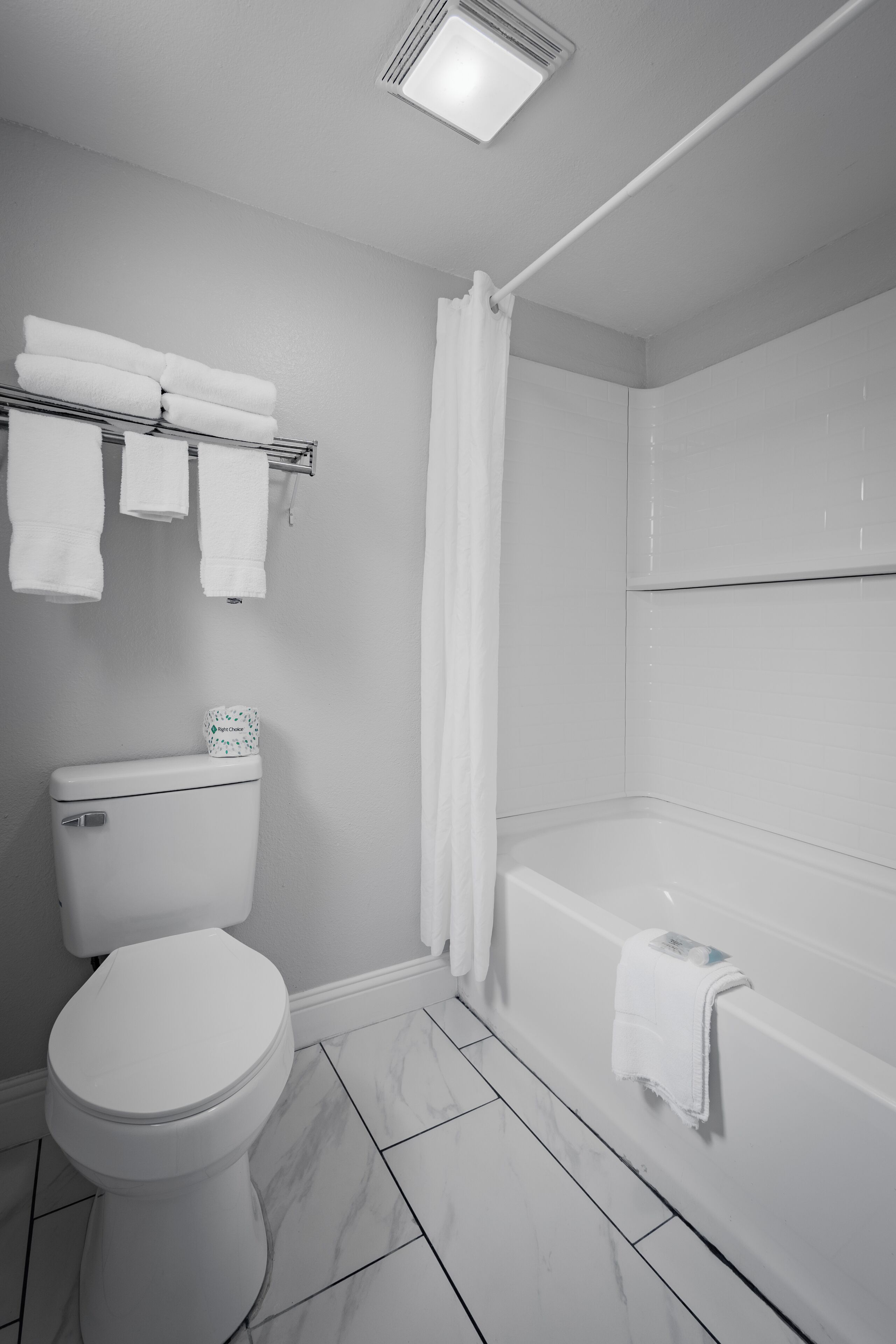 Un baño con inodoro, bañera y cortina de ducha.