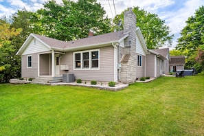 A single-story house with a chimney, a porch, and a small front yard.