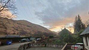A residential area with houses, a driveway, and a mountain in the background. - Ben Lomond Cottage - Loch Lomond and Arrochar Alps (Arrochar)