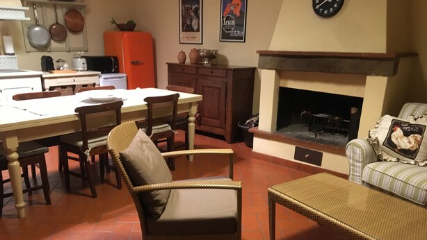 Un salon chaleureux avec une cheminée, un coin repas et une cuisine.