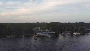 A waterfront view with a dock and a building with a blue roof.