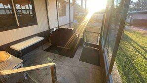 A covered patio area with a bench, a table, and a grill. - Beautiful  Water Front  Cabins (Georgetown)