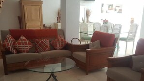 A living room with a sofa, armchairs, and a glass coffee table. - private Villa Marrakech : Villa nahellan (Marrakech)