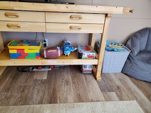 A wooden desk with drawers, a toy airplane, a football, and a toy train.