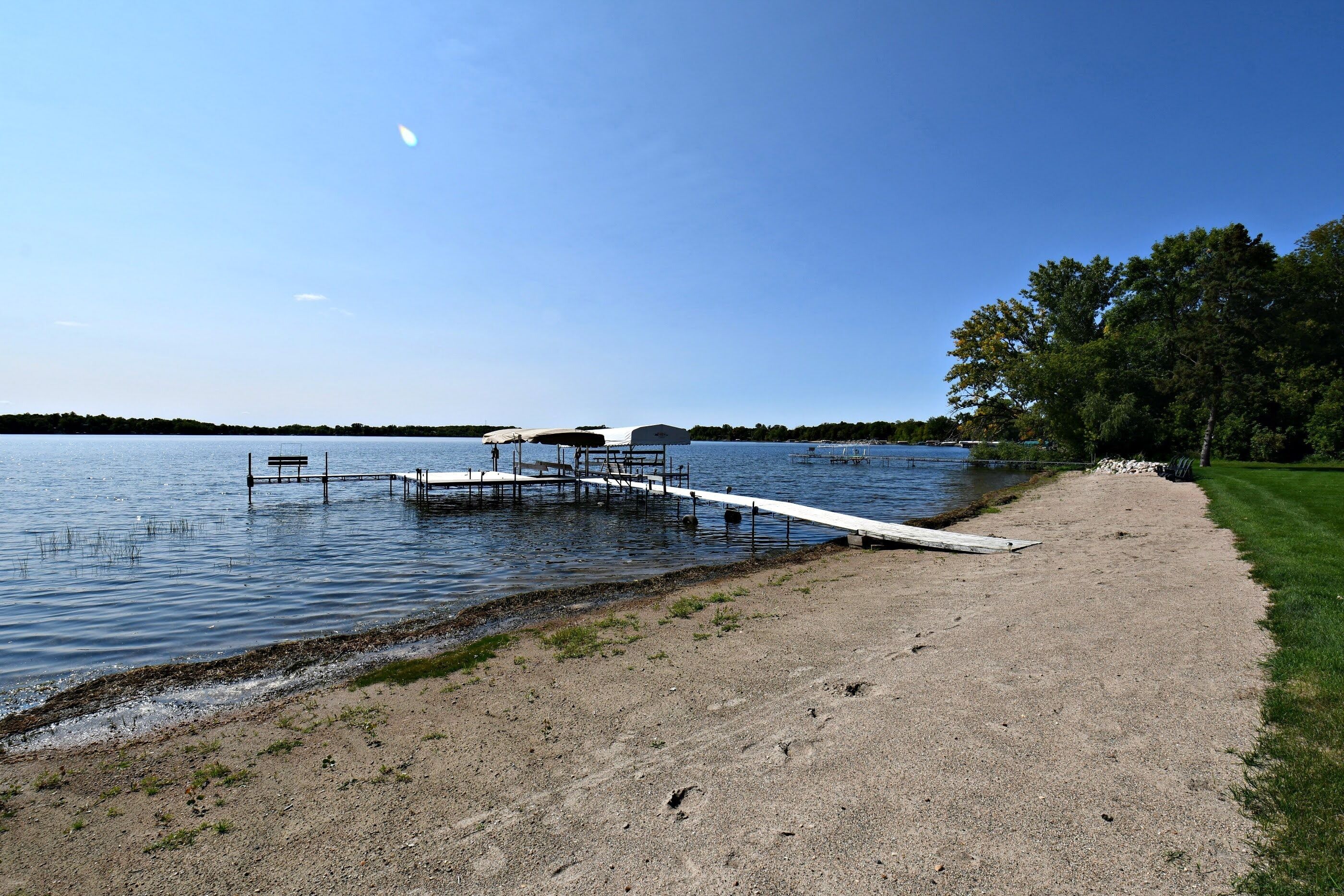 Beach and dock on level lot with sand for outdoor fun