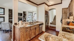 A modern kitchen with wooden cabinets, granite countertops, and a stainless steel refrigerator. - 1-10 N. Fairway Drive (Avon)