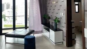 A modern living room with a sofa, ottoman, and a view of the city through large windows. - Beautiful view, 13th floor, modern, exclusive and comfortable apartment. (Santiago De Los Caballeros)
