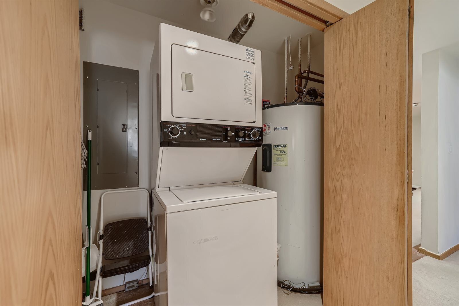 A compact laundry room with a washer, dryer, and water heater.