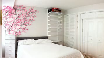A bedroom with a bed, a dresser, a white wardrobe, and a shelving unit against the wall.