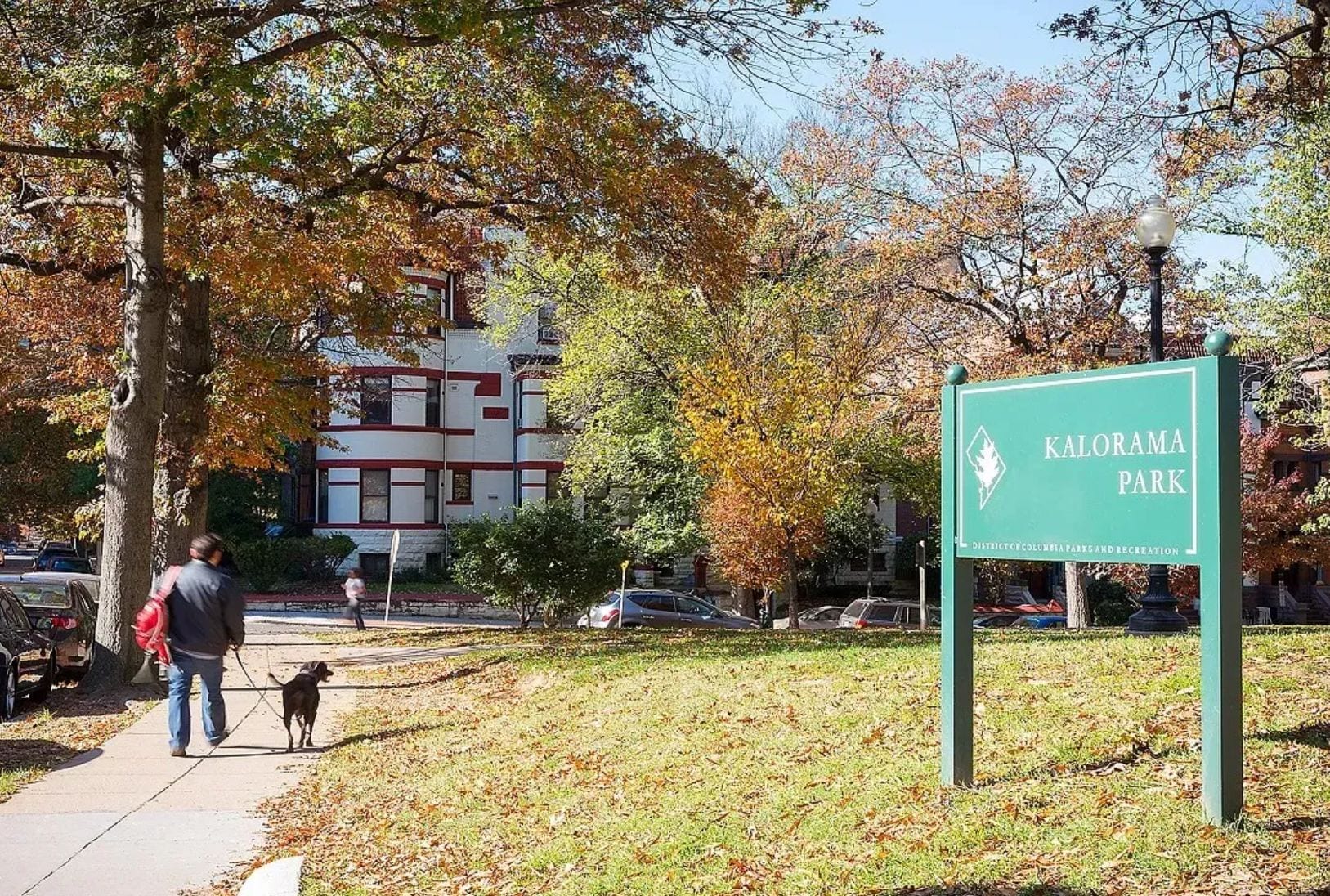 A sign for Kalorama Park with a clear sky and autumn leaves.