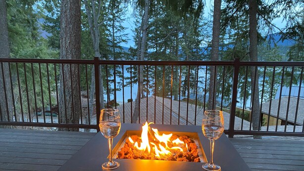 A wooden deck with a square fire feature and two glasses of water.