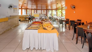 A buffet setup with various food items and a long table covered with a white tablecloth. - Hotel Casa Blanca Porto Seguro (Porto Seguro)