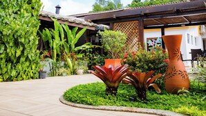 A garden with various plants and a large terracotta pot. - Hotel Casa Blanca Porto Seguro (Porto Seguro)
