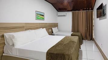 Een hotelkamer met twee bedden, een houten plafond, een schilderij aan de muur en een airconditioner.