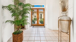 Ein Flur mit Blumentopf, Vase und einer Tür zu einem Innenhof.