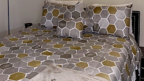 Une chambre à coucher avec un lit, des appliques murales décoratives et une literie à motifs.