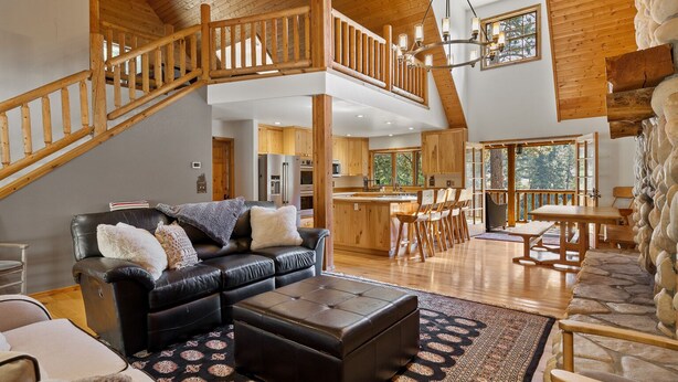 A spacious living area with a high ceiling, wooden staircase, and a cozy seating arrangement. - Private Cabin on 3 Acres for Outdoor Enthusiasts  (Cle Elum)