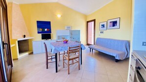 A compact living space with a dining area, kitchenette, and a sofa.