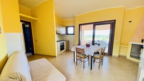 A compact living space with a kitchenette, dining area, and a sofa.