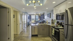Una cocina moderna con una isla central, electrodomésticos de acero inoxidable y una lámpara en el techo.