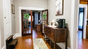 A hallway with wooden flooring, a coffee machine, a desk, and a chair. - Country house minutes from Aggieland  (College Station)