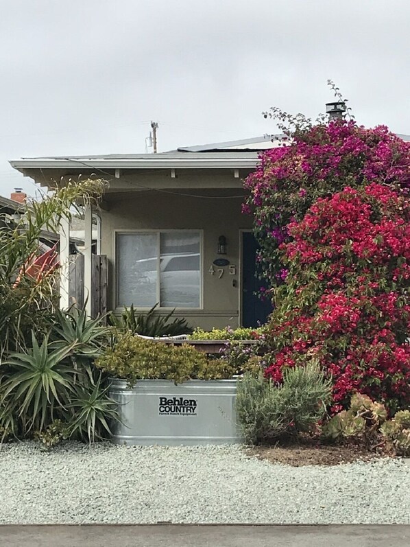 A residential house with a front door, a mailbox, and a Behlens Country sign.