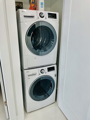 A stacked washer and dryer unit with a control panel and a digital display.