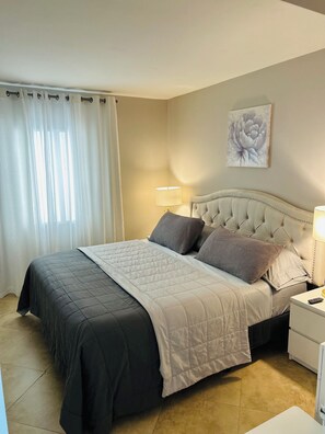 A neatly made bed with a quilted bedspread, a headboard, and two pillows.