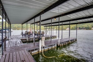 Eine überdachte Anlegestelle mit Holzplanken, Metallgeländern und einer Wasserpumpe.
