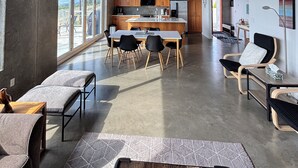 Une cuisine moderne avec des meubles en bois, un îlot central et un coin repas comprenant une table et des chaises.