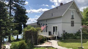 Une maison avec un porche, un drapeau américain et une vue sur un lac.